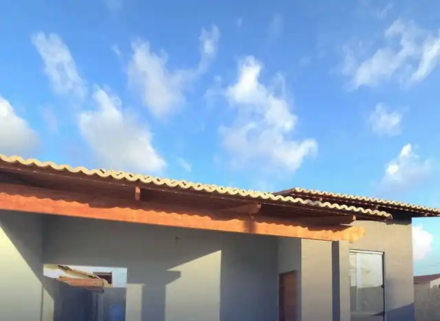 Fachada da casa de 65 m² com varanda e pergolado
